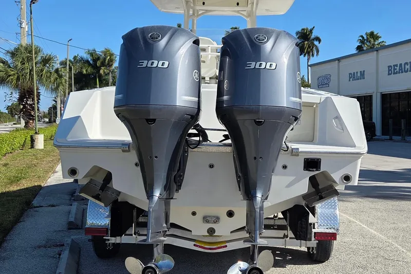 Slide: The Image of 2015 Jupiter 30 FS boat with dual Yamaha 300 engines, parked outdoors. - 2