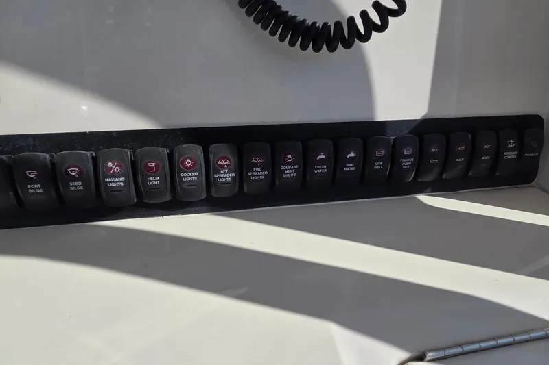 Slide: The Image of Control panel of a 2015 Jupiter 30 FS boat with labeled switches. - 22