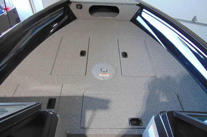 Slide: The Image of 2026 Crestliner 1850 Kodiak WT boat interior with storage compartments and carpeted deck. - 15