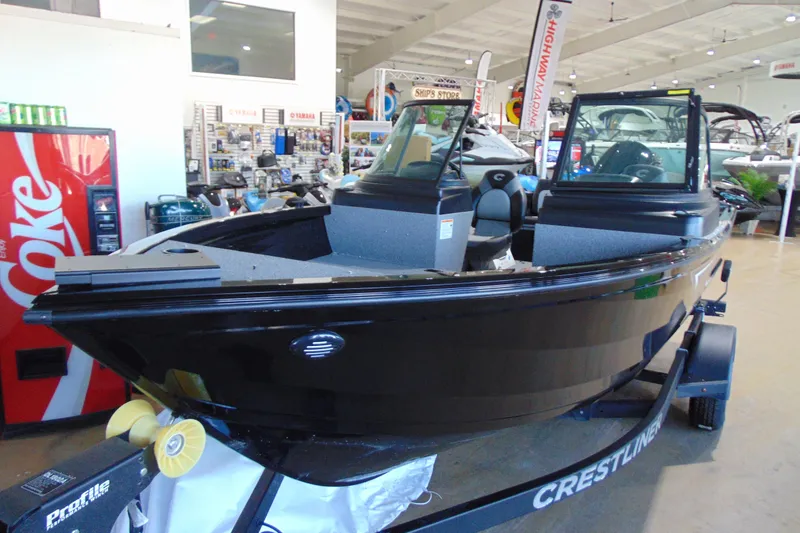 Slide: The Image of 2026 Crestliner 1850 Kodiak WT boat displayed in showroom, black exterior, on trailer. - 4