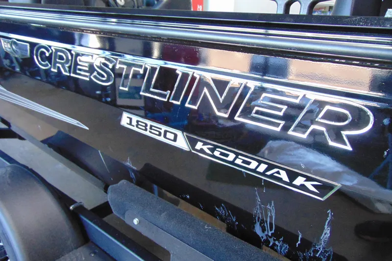 Slide: The Image of 2026 Crestliner 1850 Kodiak WT boat logo on sleek black surface. - 9