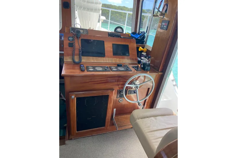 Slide: The Image of Great Harbour N37 2008 helm with wooden dashboard, steering wheel, and navigation equipment. - 2