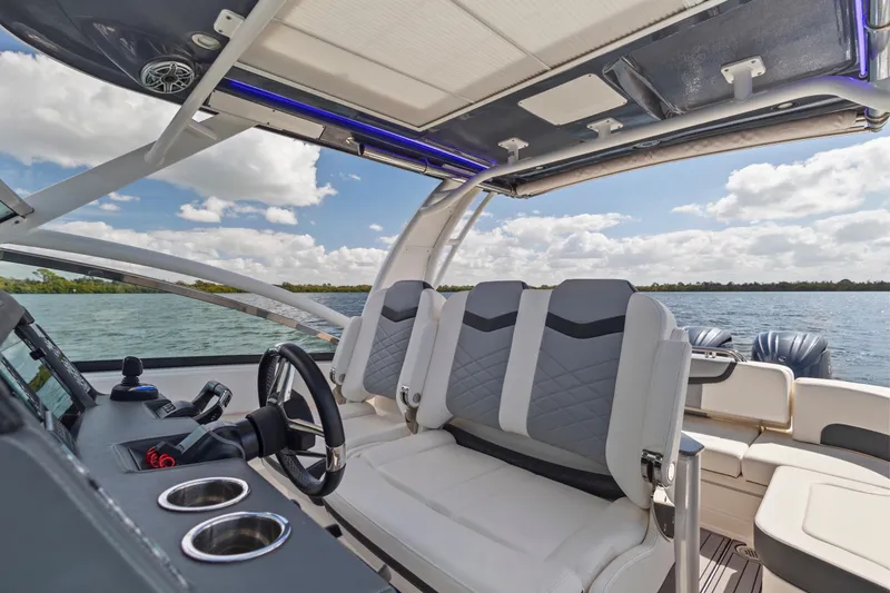 Slide: The Image of 2022 Chaparral 300 OSX boat interior with modern seating and steering wheel on open water. - 18