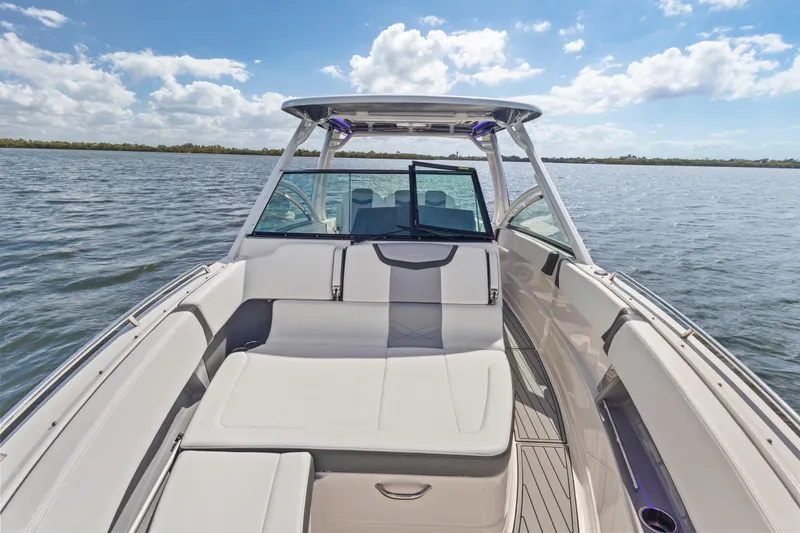 Slide: The Image of 2022 Chaparral 300 OSX boat interior with seating, on a sunny day at sea. - 20