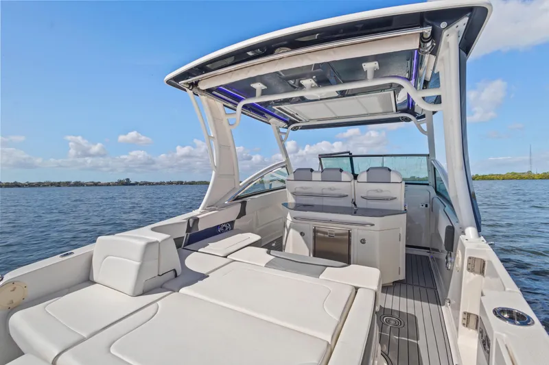 Slide: The Image of 2022 Chaparral 300 OSX boat interior with seating, open water view, and clear sky. - 9