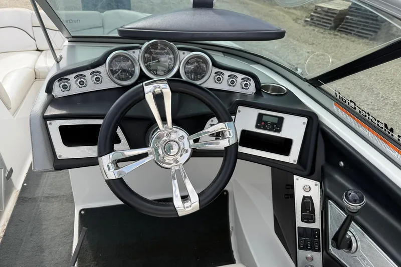 Slide: The Image of 2012 MasterCraft X2 boat dashboard with steering wheel and control panel. - 10