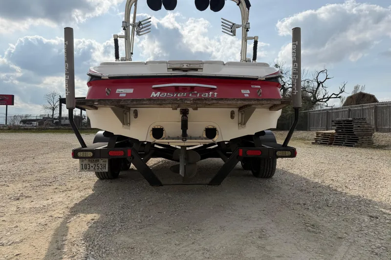 Slide: The Image of 2012 MasterCraft X2 boat on trailer, rear view, parked outdoors under cloudy sky. - 3