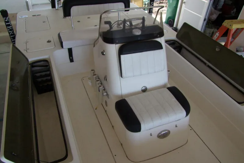 Slide: The Image of 2012 Sterling 220XS boat interior with white seating and storage compartments. - 17