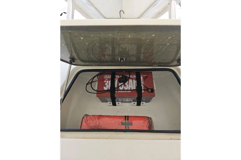 Slide: The Image of 2012 Sterling 220XS boat storage with battery and life jacket. - 22