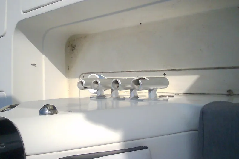 Slide: The Image of 2012 Sterling 220XS boat interior with rod holders and storage compartment. - 32