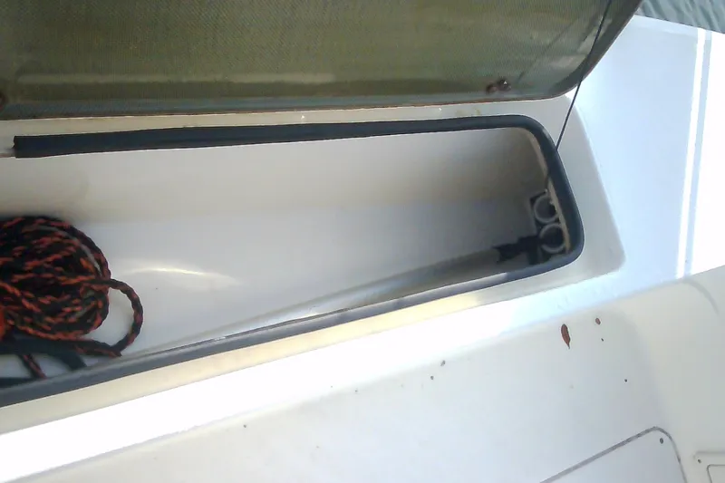 Slide: The Image of Open storage compartment on 2012 Sterling 220XS boat with coiled rope inside. - 40