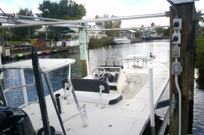 Slide: The Image of 2012 Sterling 220XS boat docked in a serene canal setting. - 49