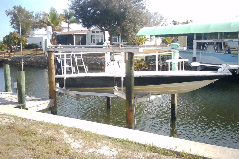 Slide: The Image of 2012 Sterling 220XS boat on lift by waterfront homes and palm trees. - 5