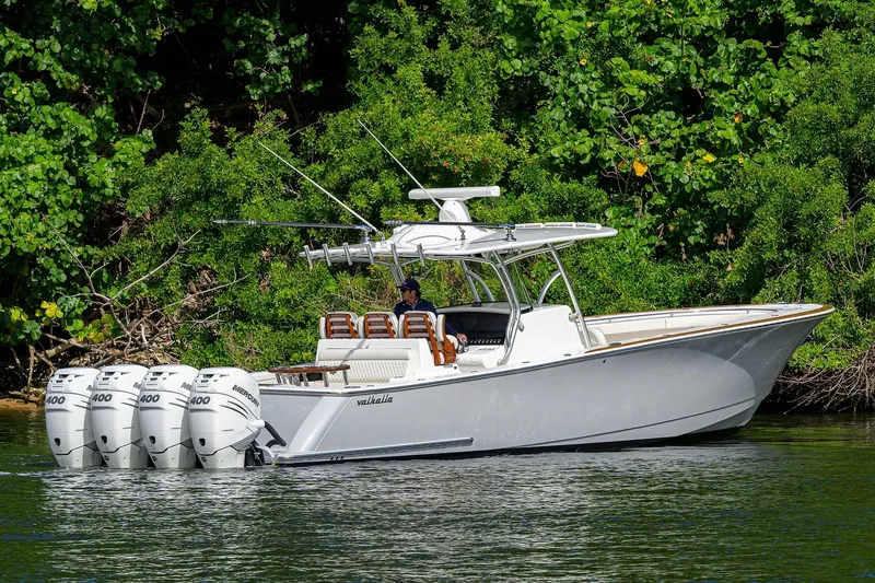 Slide: The Image of 2021 Valhalla Boatworks V-41 with four Mercury engines cruising near lush greenery. - 9