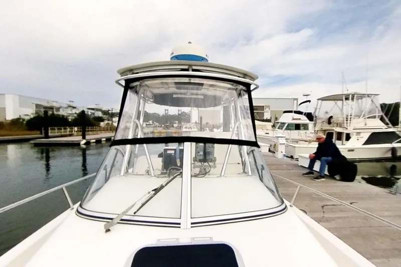 Slide: The Image of 2005 Shamrock 246 Adventurer boat docked at marina with person seated nearby. - 1