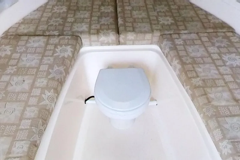 Slide: The Image of 2005 Shamrock 246 Adventurer cabin interior with patterned cushions and compact toilet. - 11