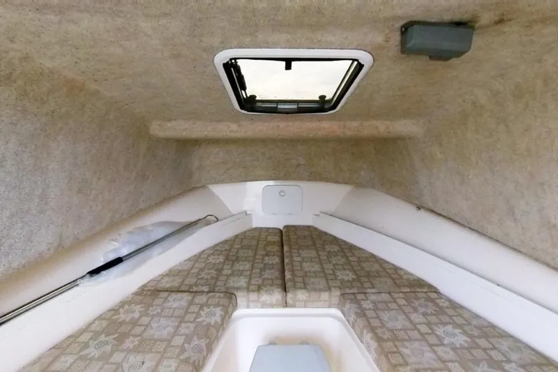 Slide: The Image of Interior cabin of 2005 Shamrock 246 Adventurer boat with cushioned seating and overhead hatch. - 12