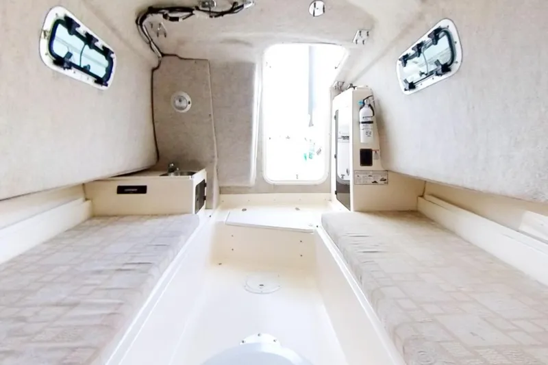 Slide: The Image of 2005 Shamrock 246 Adventurer cabin interior with twin beds and compact design. - 13