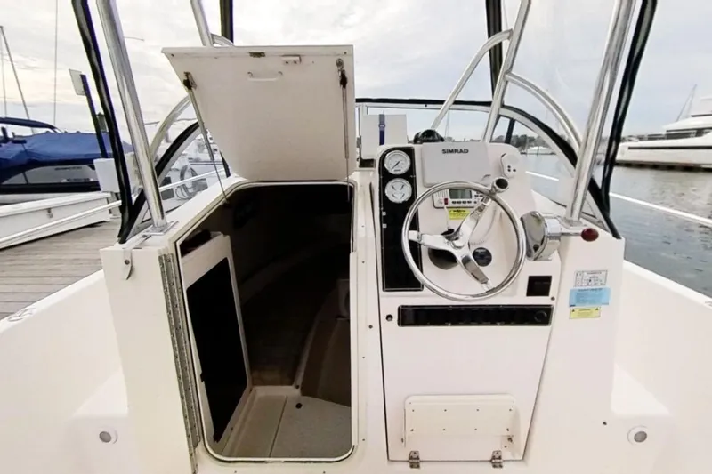 Slide: The Image of 2005 Shamrock 246 Adventurer boat helm with open cabin door at marina. - 3