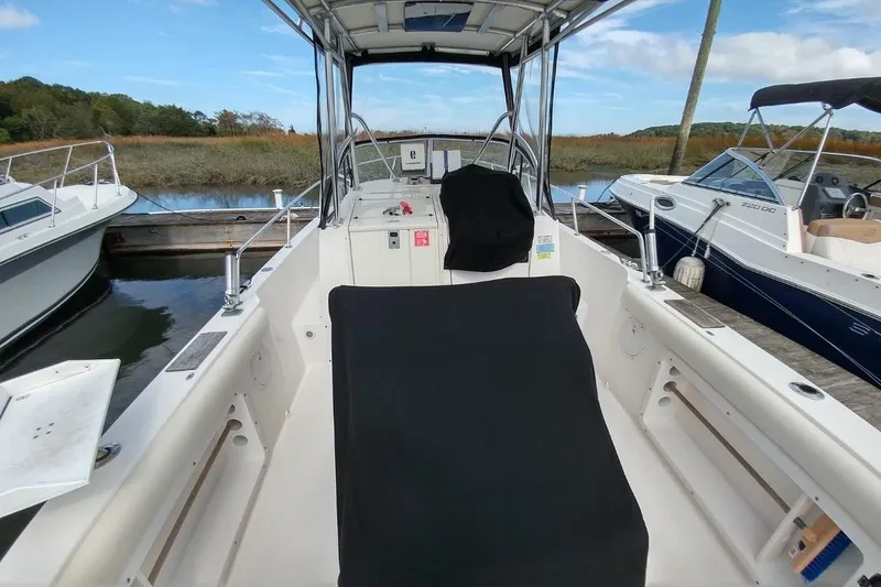 Slide: The Image of 2005 Shamrock 246 Adventurer boat docked, interior view with covered seating. - 6