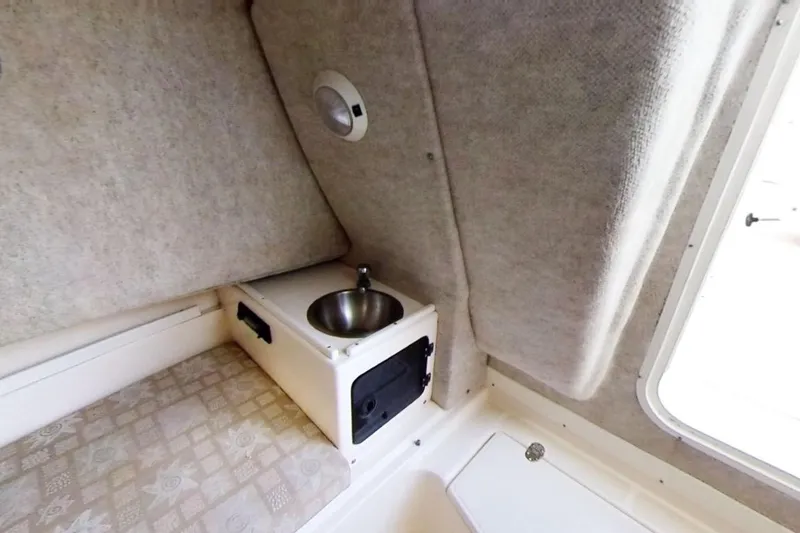 Slide: The Image of 2005 Shamrock 246 Adventurer cabin interior with sink and cushioned seating. - 9