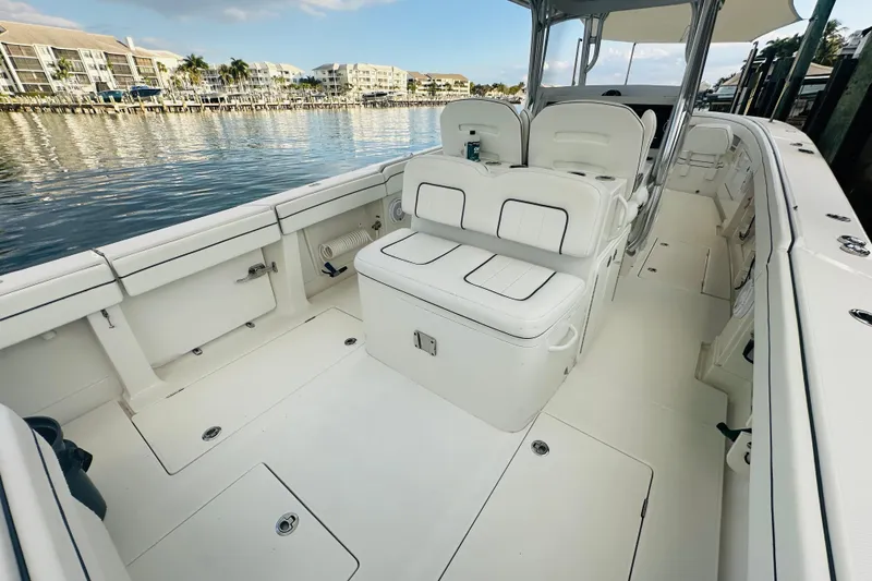 Slide: The Image of 2015 Jupiter 38 FS boat interior with white seating, docked by waterfront buildings. - 11