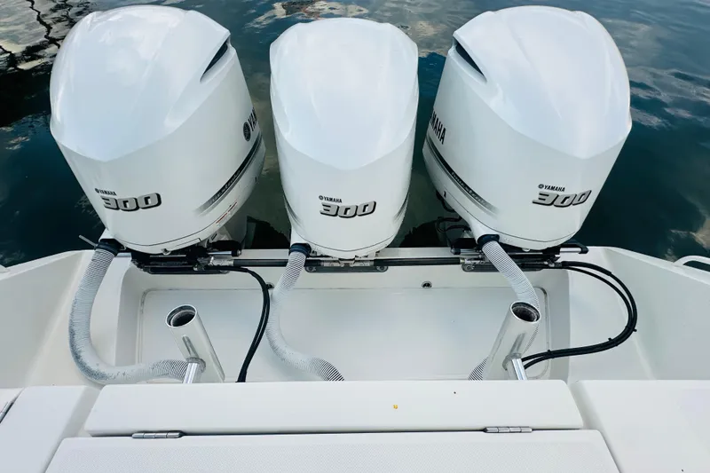 Slide: The Image of Triple Yamaha 300 engines on a 2015 Jupiter 38 FS boat, docked on calm water. - 12
