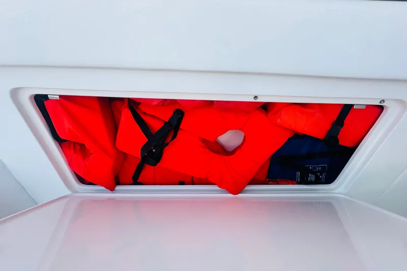 Slide: The Image of Storage compartment with red life jackets on a 2015 Jupiter 38 FS boat. - 41