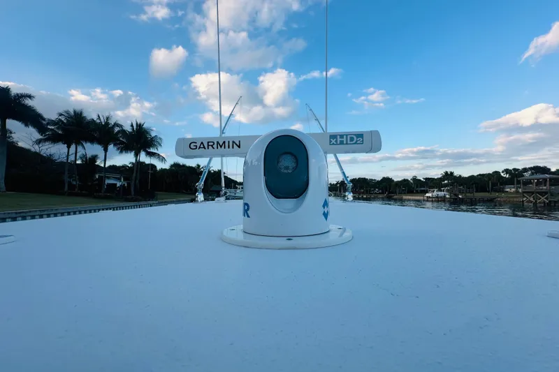 Slide: The Image of 2015 Jupiter 38 FS boat with Garmin xHD2 radar, palm trees, and blue sky background. - 42