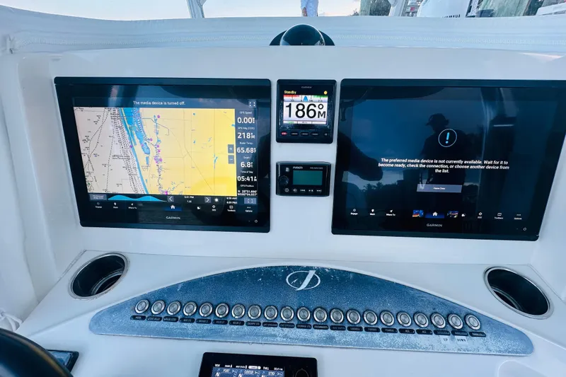 Slide: The Image of Control panel of a 2015 Jupiter 38 FS boat with navigation screens. - 48
