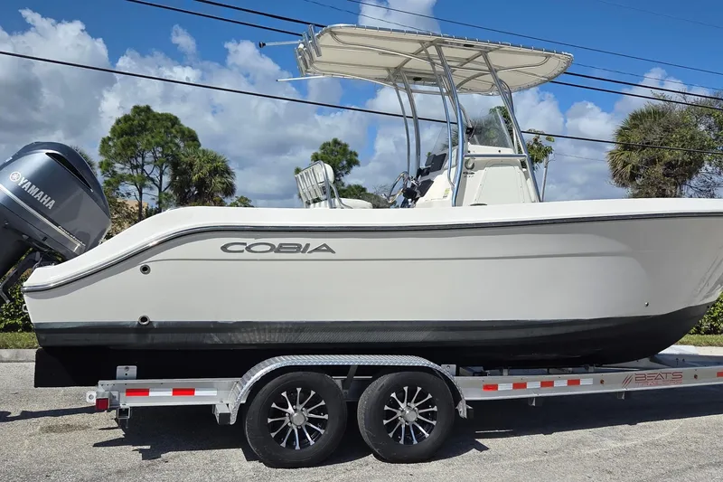 Slide: The Image of 2020 Cobia 237 Center Console boat on trailer with Yamaha engine, under blue sky. - 3