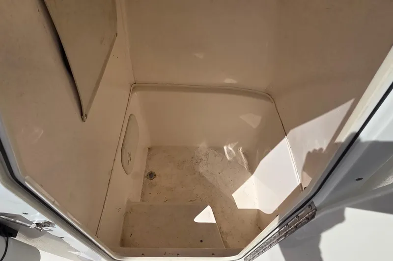 Slide: The Image of 2020 Cobia 237 Center Console storage compartment interior, clean and spacious design. - 7