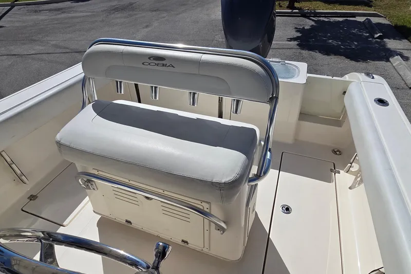 Slide: The Image of 2020 Cobia 237 Center Console boat interior with cushioned seating and rod holders. - 8