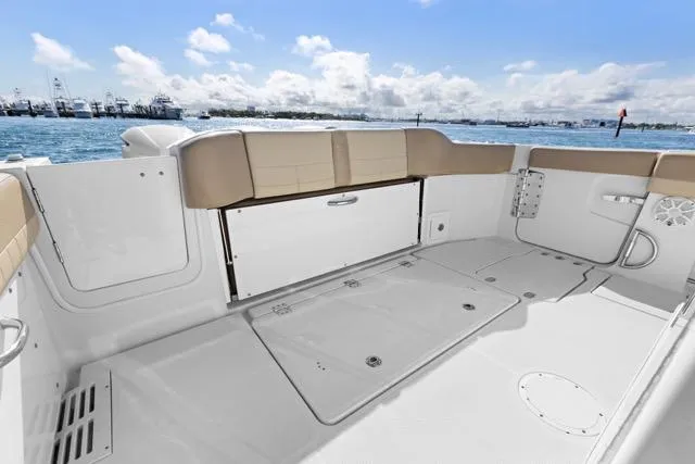 Slide: The Image of 2019 Sailfish 360 CC boat deck with seating, overlooking a scenic waterfront. - 13