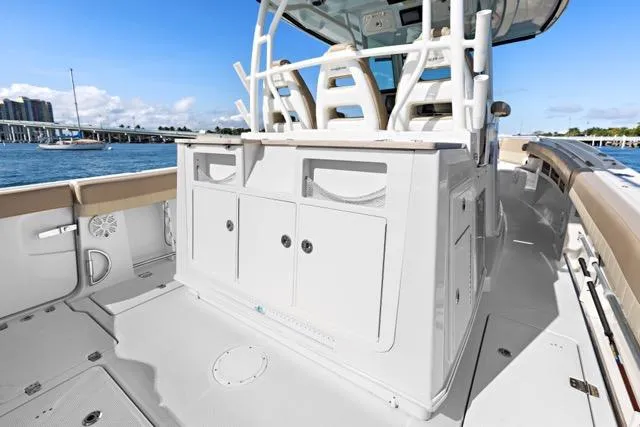 Slide: The Image of 2019 Sailfish 360 CC boat interior with seating and storage, docked by the water. - 15