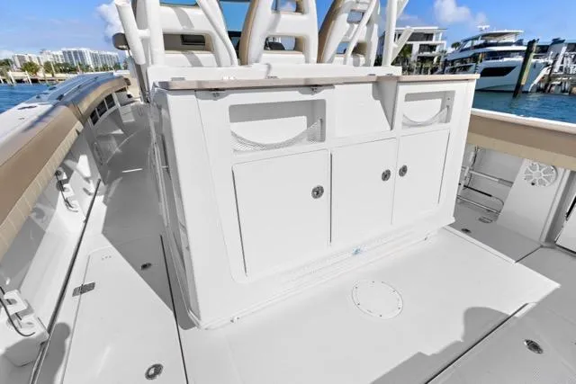 Slide: The Image of 2019 Sailfish 360 CC boat interior with storage compartments, docked by the water. - 17