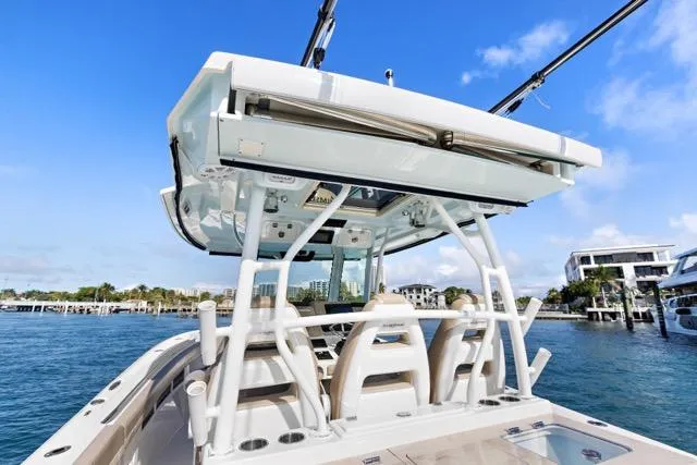 Slide: The Image of 2019 Sailfish 360 CC boat on water, showcasing helm and seating area under clear blue sky. - 18