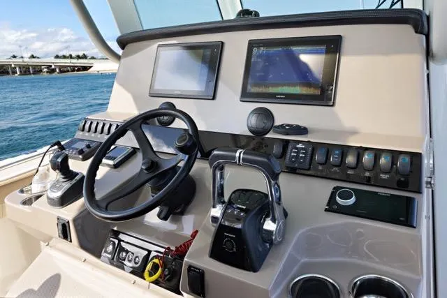 Slide: The Image of 2019 Sailfish 360 CC boat dashboard with steering wheel, dual screens, and control panel. - 20