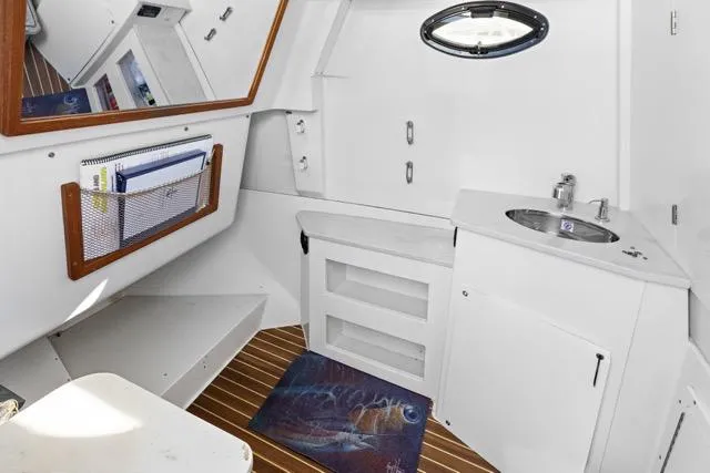 Slide: The Image of 2019 Sailfish 360 CC boat interior with sink, storage, and wooden flooring. - 25