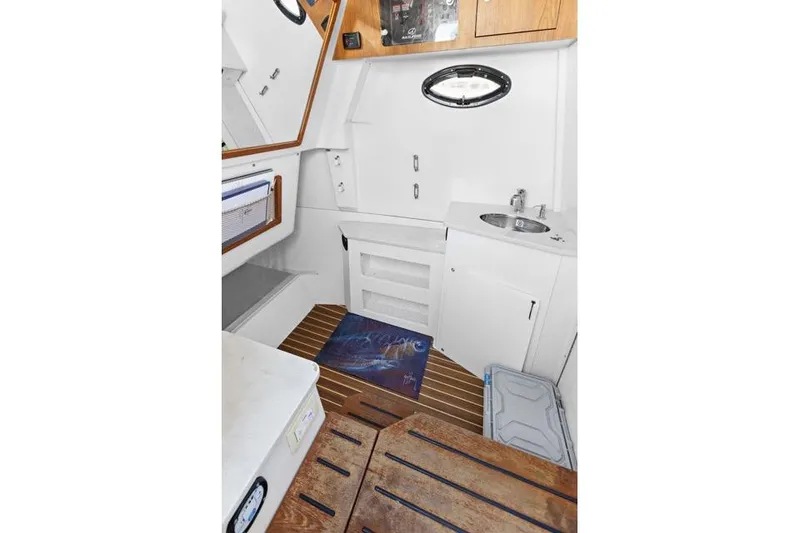 Slide: The Image of 2019 Sailfish 360 CC cabin interior with sink, storage, and wooden flooring. - 26
