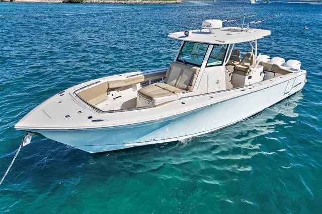 Slide: The Image of 2019 Sailfish 360 CC boat on clear blue water, showcasing sleek design and spacious deck. - 4