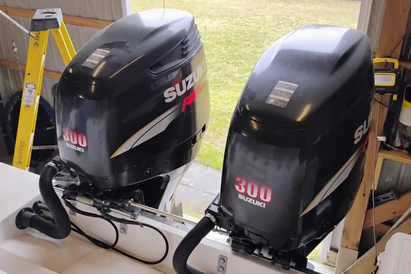 Slide: The Image of Twin Suzuki 300 outboard engines on a 2009 McKee Craft 28 boat in a garage. - 12