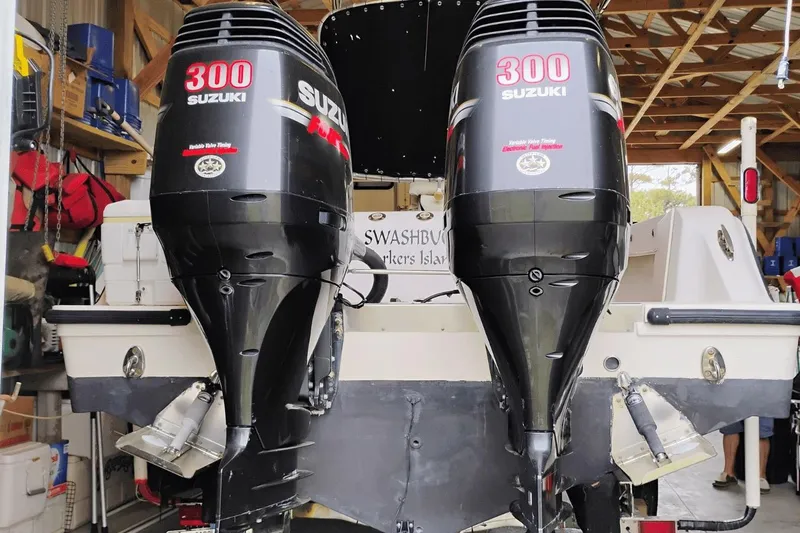Slide: The Image of 2009 McKee Craft 28 boat with dual Suzuki 300 outboard engines in a garage. - 13