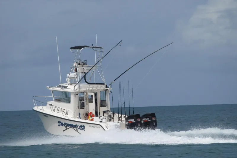 Slide: The Image of 2009 McKee Craft 28 boat cruising on the ocean with fishing rods and Suzuki engines. - 15