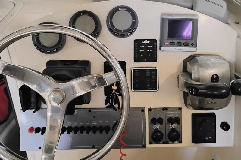 Slide: The Image of 2009 McKee Craft 28 boat dashboard with steering wheel, gauges, and controls. - 6