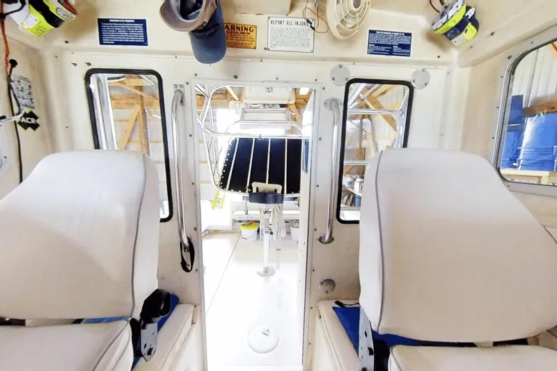 Slide: The Image of Interior view of 2009 McKee Craft 28 boat with white seating and equipment. - 9