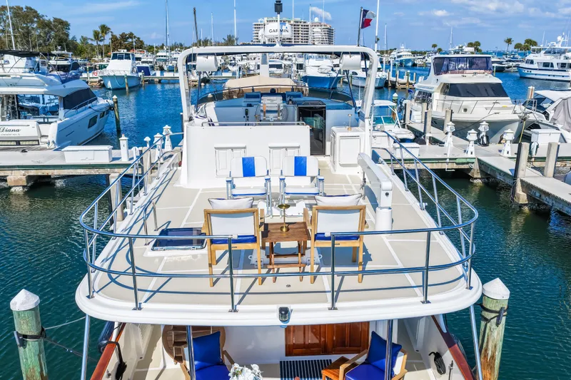 Slide: The Image of 2008 DeFever 52 Euro yacht docked at marina, featuring spacious deck and seating area. - 10