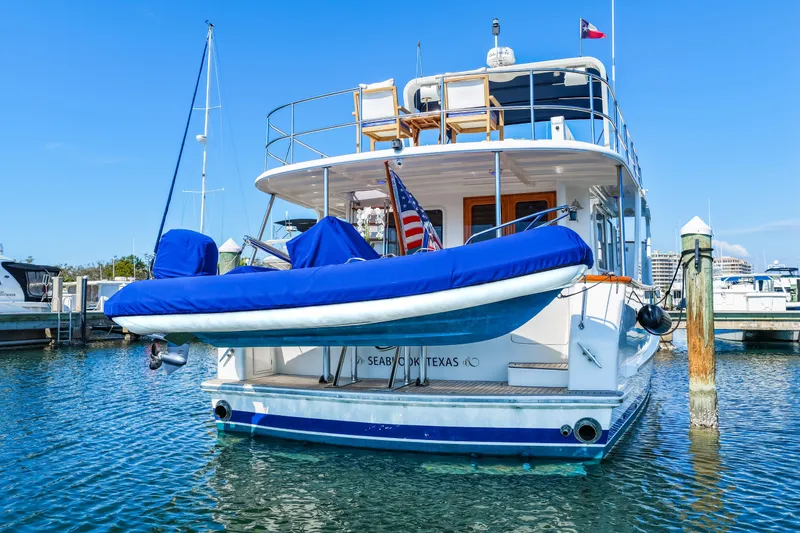 Slide: The Image of 2008 DeFever 52 Euro yacht docked, featuring blue covers and American flag. - 13