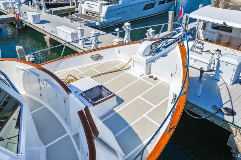 Slide: The Image of 2008 DeFever 52 Euro yacht docked at marina, showcasing spacious deck and sleek design. - 18