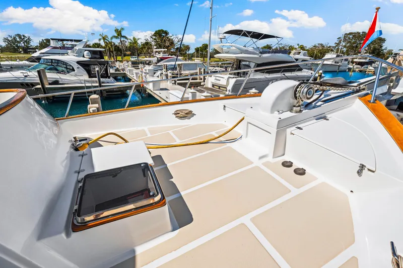 Slide: The Image of 2008 DeFever 52 Euro yacht deck with winch, docked in marina under blue sky. - 28